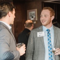 2 GVSU Alumni talk to each other while holding cups